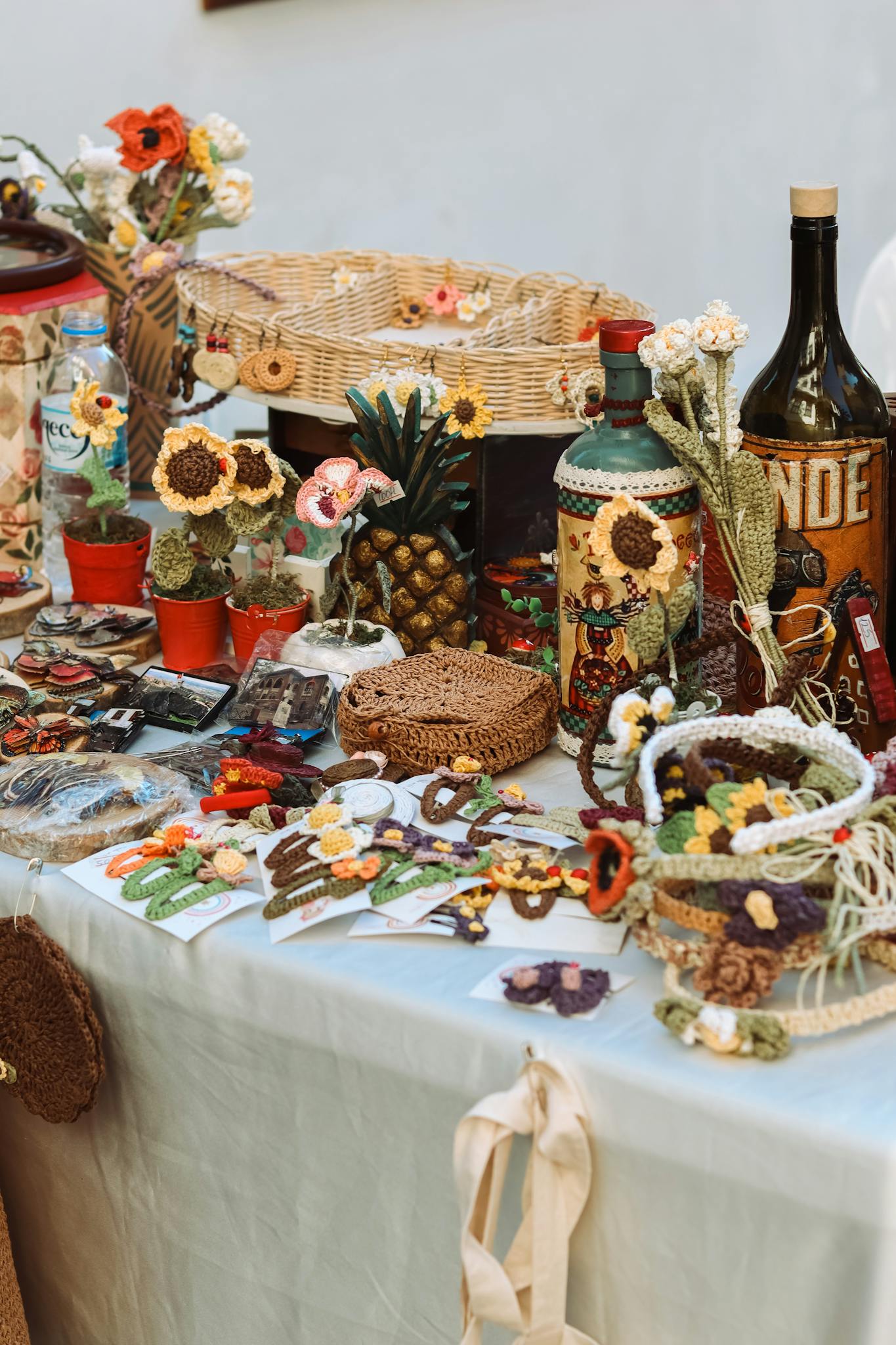 Colorful market table displaying handcrafted items including woven baskets, ceramics, and decorations.